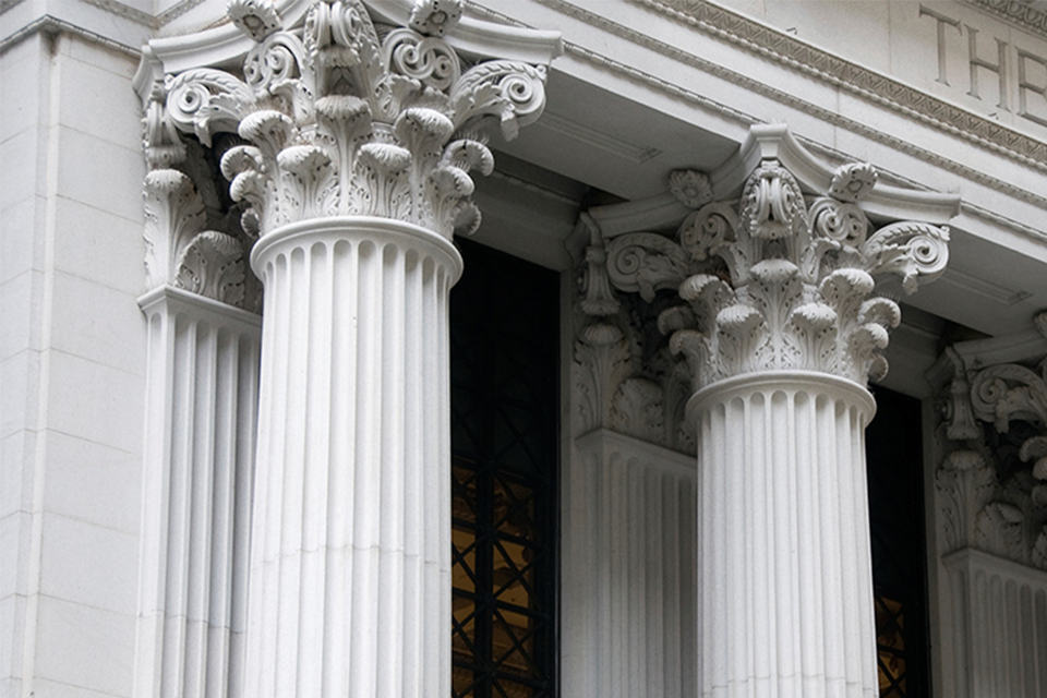 Close up image of white courthouse columns.
