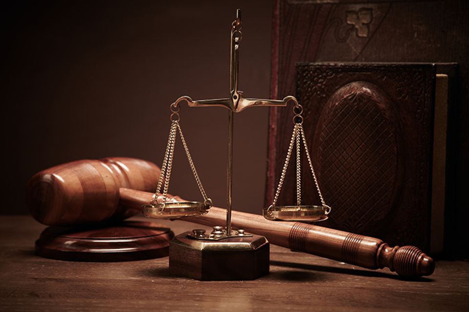 Image of scales a gavel pictured in a courtroom setting.