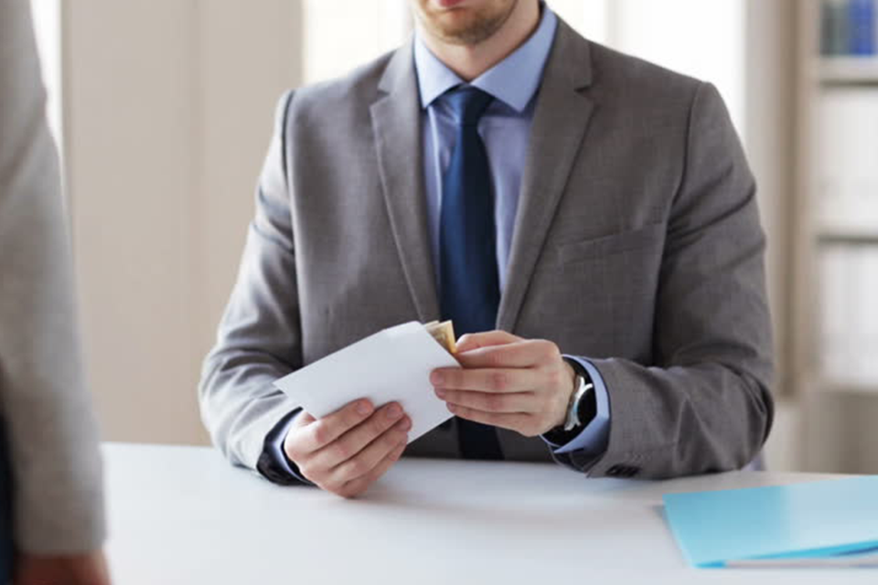 Image of a person receiving money in an envelope compensating for monetary damages.